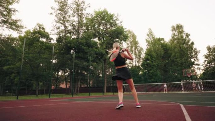 女子网球运动员在夏日开放运动场的网球场上训练