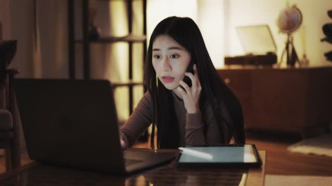 疲倦的年轻女性使用笔记本电脑工作到深夜