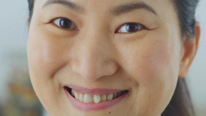 一名亚洲女子微笑着对着镜头的SLO MO TU脸