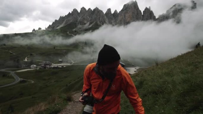男子摄影师在多洛米蒂山脉的高山徒步旅行: 恶劣的天气
