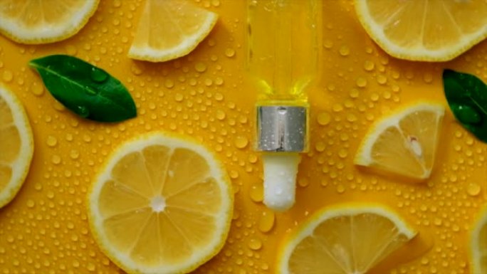 柠檬精油在黄色背景与水滴。选择性聚焦。食品。