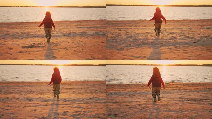 快乐的小男孩在日落，童年的时刻和幸福中奔跑在河的沙滩上