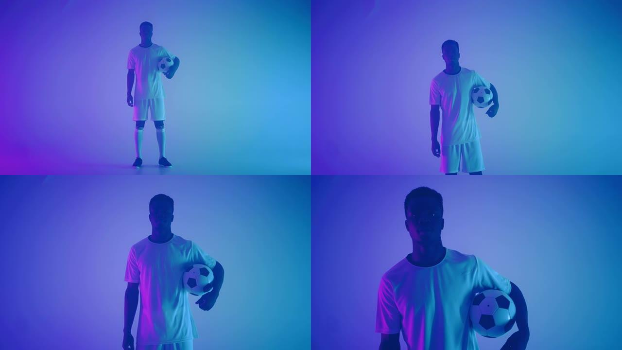 穿着白色制服的黑人职业足球运动员的慢动作肖像，在摄影棚的蓝红色霓虹灯中看着相机。一个残酷的足球运动员