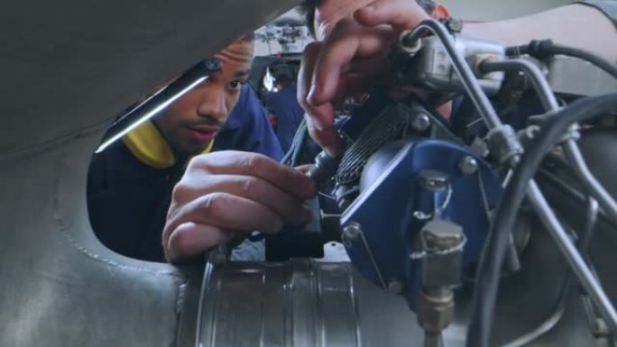 DS高级维修技术员教一名年轻的机械师如何在直升机上连接电缆