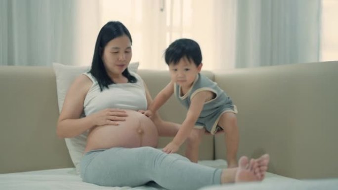 亚洲孕妇和儿子在家放松