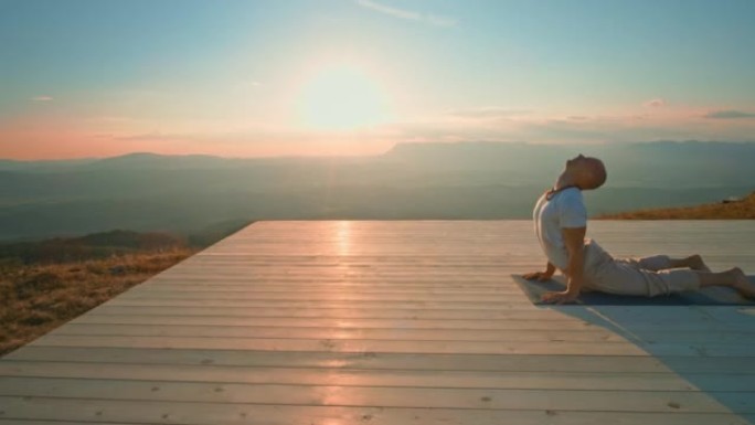CS男子在阳光明媚的山顶上做瑜伽