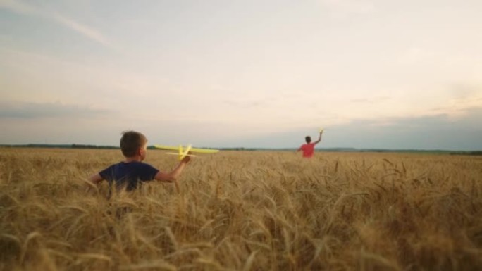 乡村快乐的童年，小男孩在金色的田野里奔跑，在玩飞机