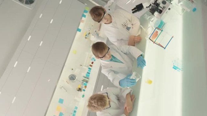 孩子们在实验室进行科学实验。用移液管倒多色液体。特写