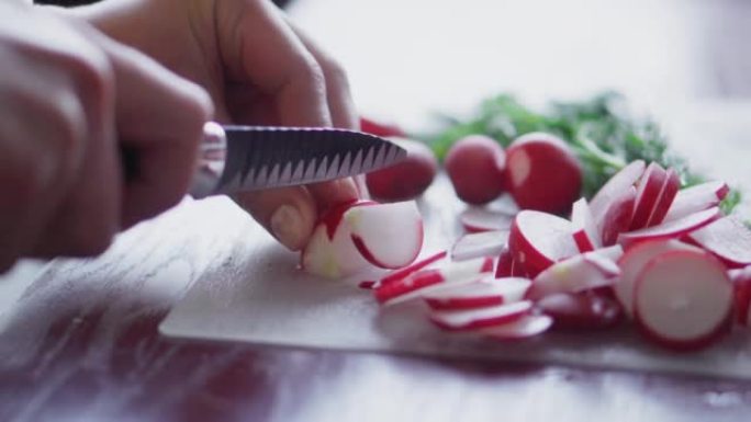 Radishes are cut with a knife on the table. Cuttin