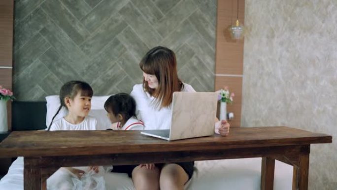社交电话会议，亚洲女儿和单身母亲通过带有无线互联网系统的计算机上在线课程。