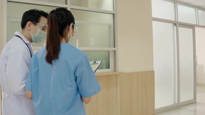 在医院走廊，医生边走边聊。