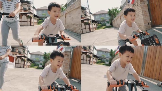 微笑的蹒跚学步的男孩在户外骑自行车