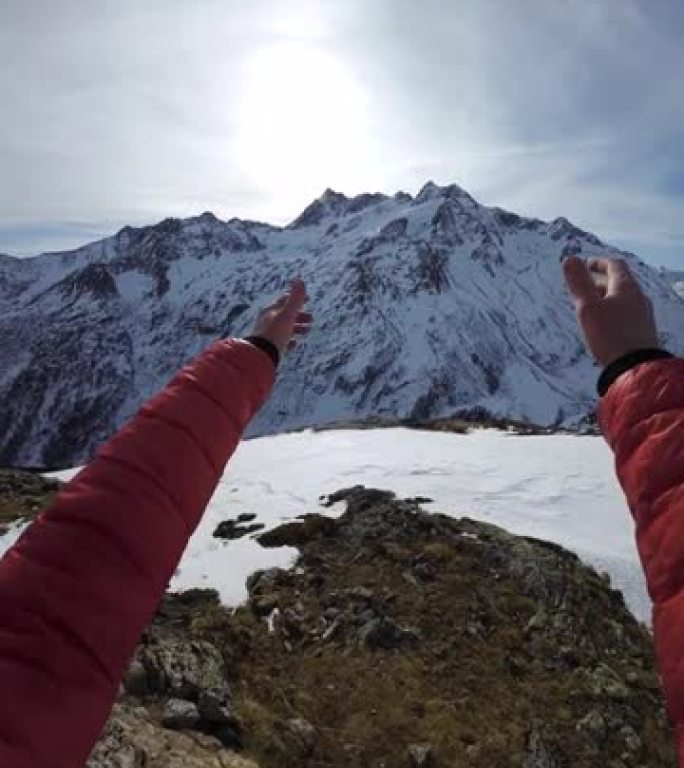 山顶上滑雪者的第一人称视角，在大山脉前摆自由姿势