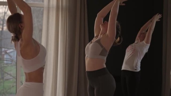 In slow motion, a yoga instructor conducts a group
