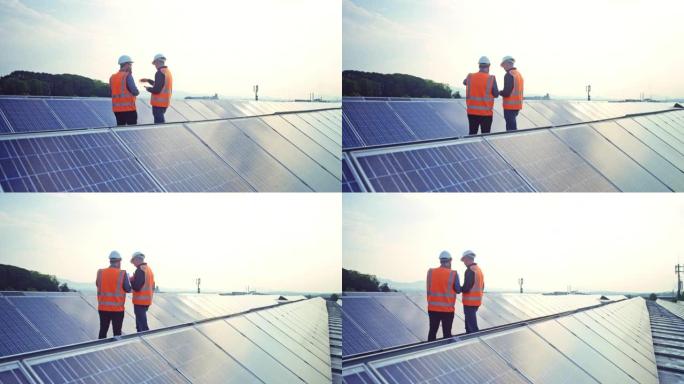 两名男工程师在太阳能发电厂的屋顶上进行讨论