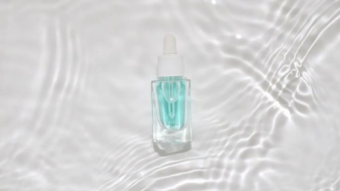 化妆品瓶，水瓶在水面上滴。反射阳光和阴影的纯净水。波浪水的慢动作。设计包装视频，化妆品广告