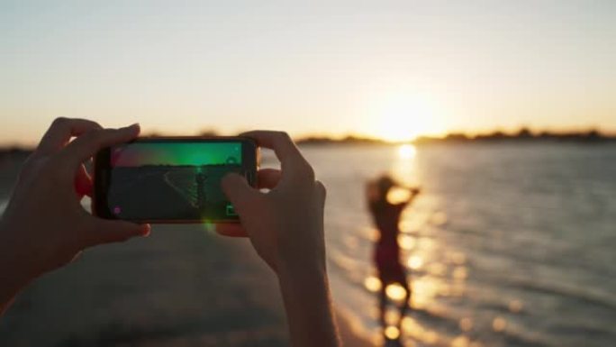 POV在海滩上拍摄一个女人的电话照片