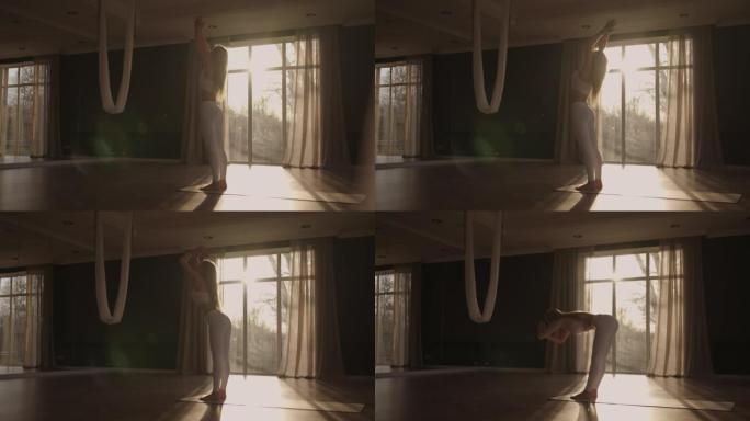 一位穿着白色运动服的年轻女子正伸展着一个大大厅，大厅里有大窗户，以慢动作的方式，阳光透过窗户。