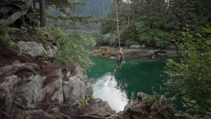 一名男子用绳子从悬崖上跳入水中的镜头