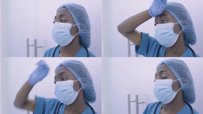 疲倦的非洲裔美国医生擦拭出汗的额头，疲惫，压力