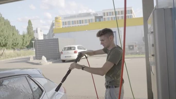 一名男子在洗车场用肥皂水洗车