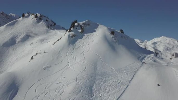 一名滑雪者在雪山上下山的空中无人机拍摄