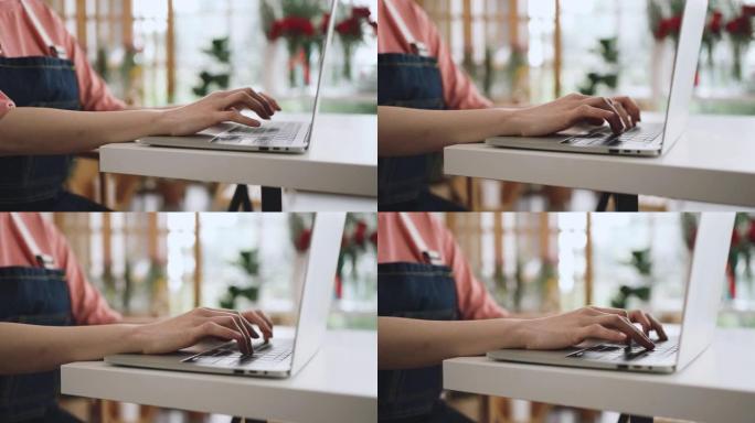 女性手在办公桌上用笔记本电脑打字