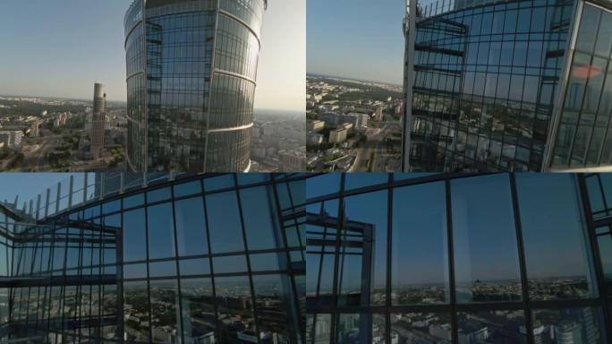 映照蓝天的玻璃摩天大楼。FPV无人机向建筑物移动