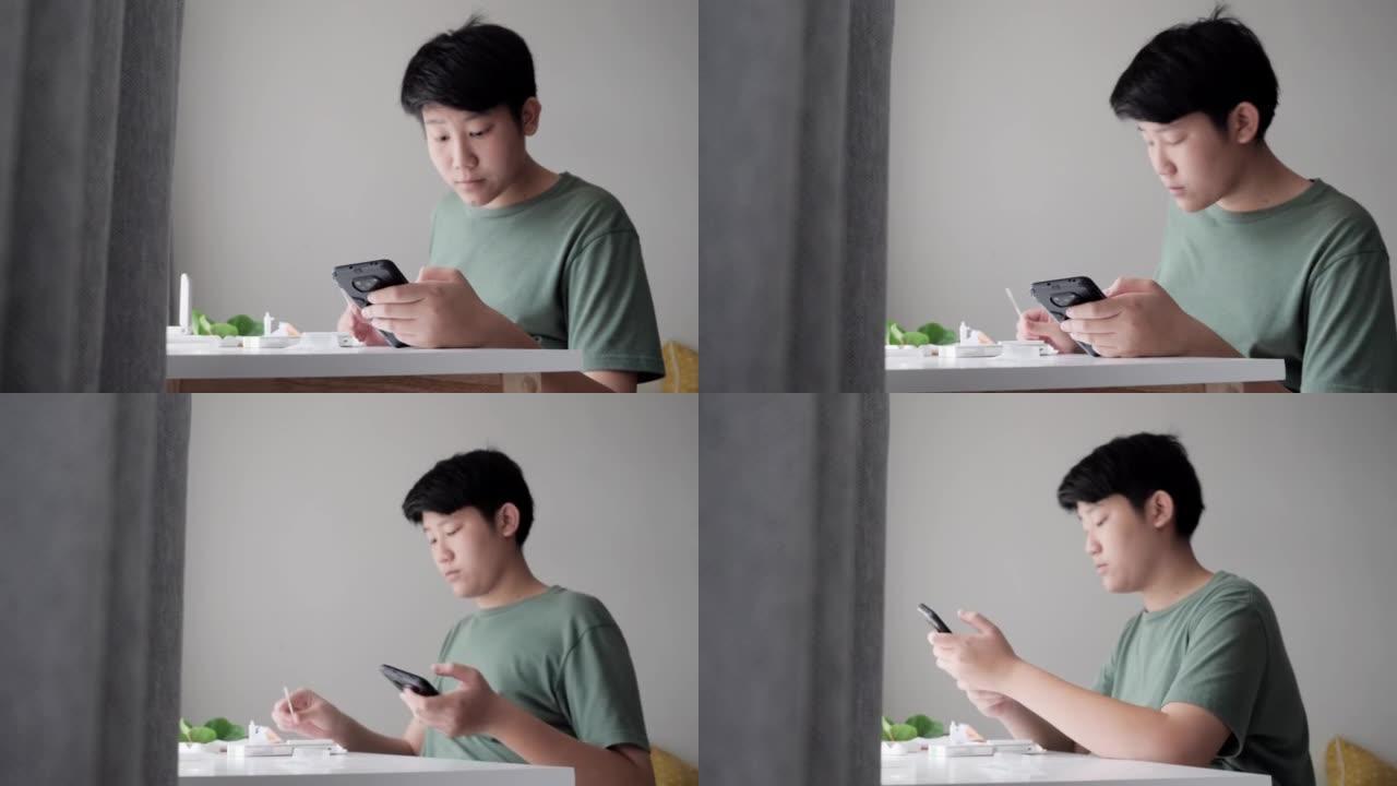亚洲男孩通过智能手机制作视频，用于在家中使用新型冠状病毒肺炎进行快速测试，然后在在线教室发送给他的老
