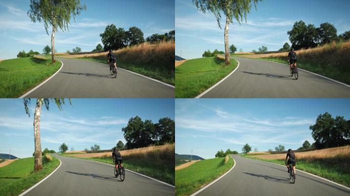 自行车和铁人三项概念。专业公路自行车手骑自行车，爬坡。运动健美女运动员在柏油路上骑自行车训练，做有氧