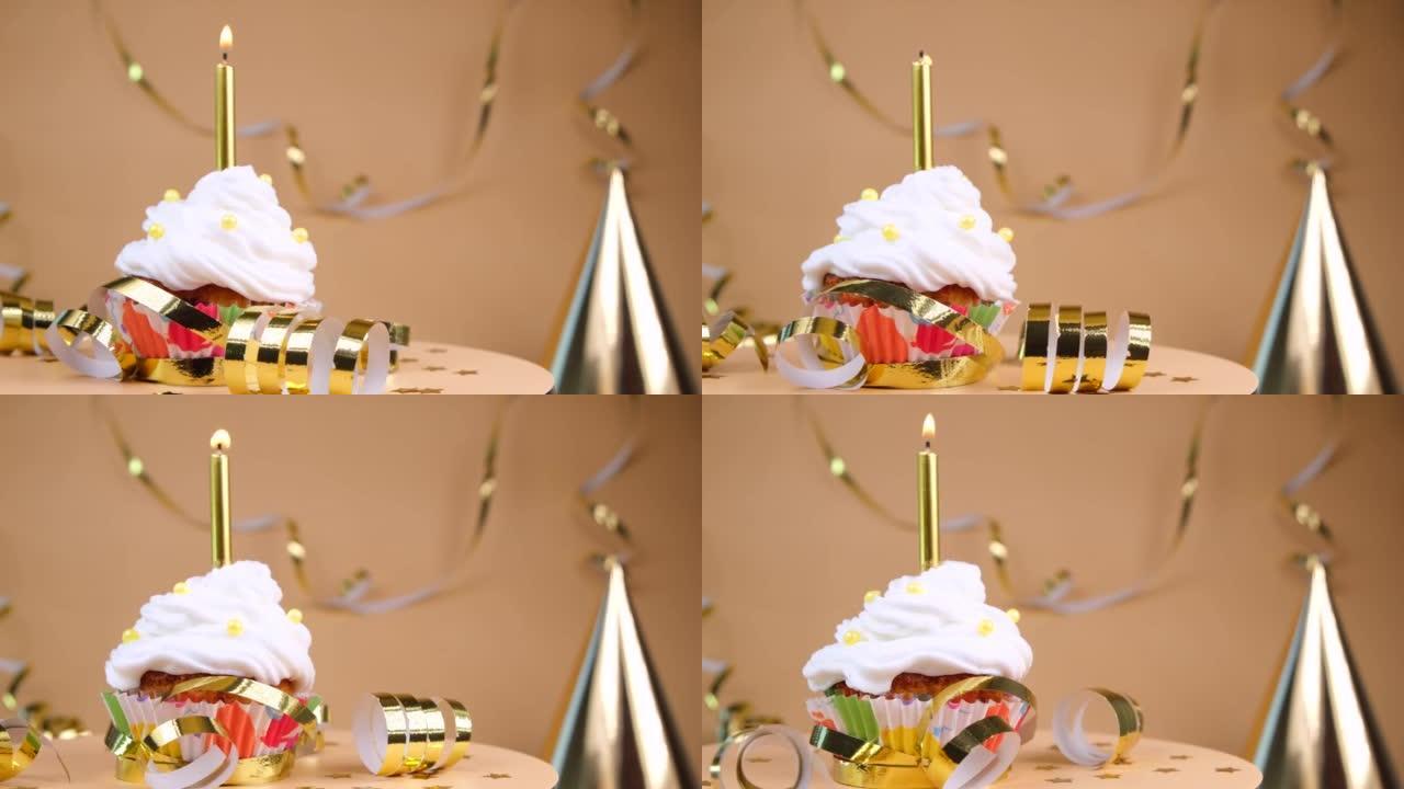 生日蛋糕或纸杯蛋糕，米色背景上有燃烧的金色蜡烛。庆祝派对的概念，金色的周年纪念