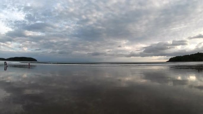 日出时的潮滩和远处冲浪的风景