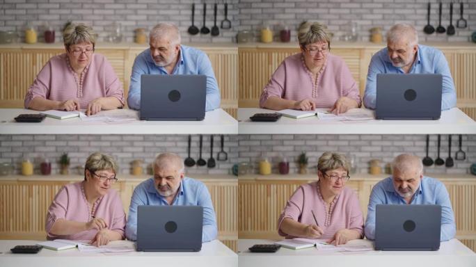 老年已婚夫妇正在计算他们的水电费账单，坐在房子里的厨房里，中等肖像