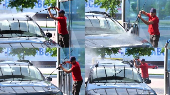 年轻的白人男性工人在阳光明媚的日子在户外用高压水洗车。英俊的男人在汽车清洁单元工作清洁车辆。工作概念
