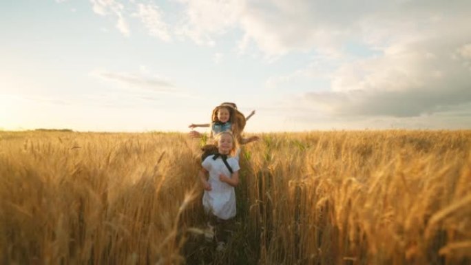 三个可爱的小女孩在阳光明媚的夏天，在金色的小麦或黑麦上奔跑，快乐无忧无虑的童年