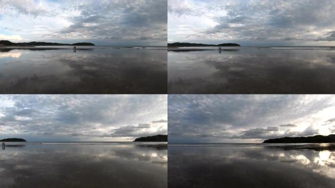 日出时的潮滩和远处冲浪的风景