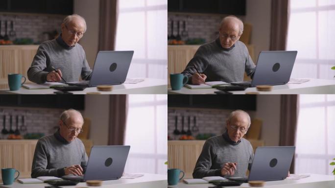 老人正在家里用笔记本电脑工作，用计算器计算，用笔记本电脑发送信息，退休人员的肖像