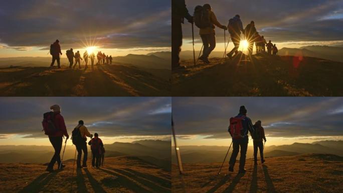 空中SLO MO一群人在日落时在山顶徒步旅行