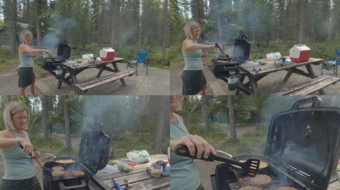 一名妇女在荒野营地做饭的动态镜头