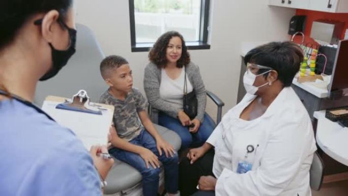 医生和小男孩谈话时，母亲和护士点头示意