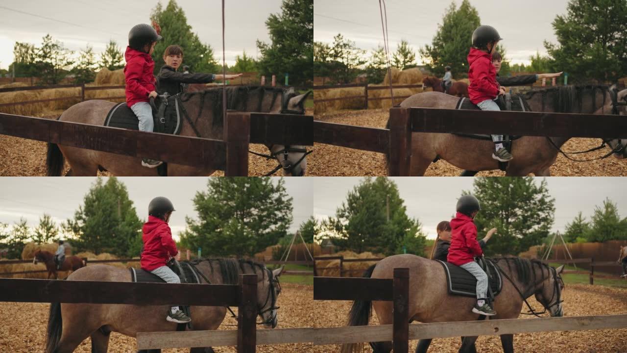 小马俱乐部的儿童海马疗法，小男孩坐在马背上，女教练在教他