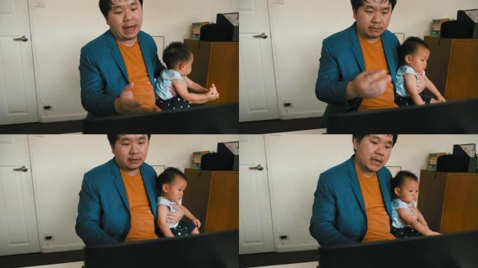 新常态: 父亲在笔记本电脑上进行视频通话时抱着他的宝贝儿子