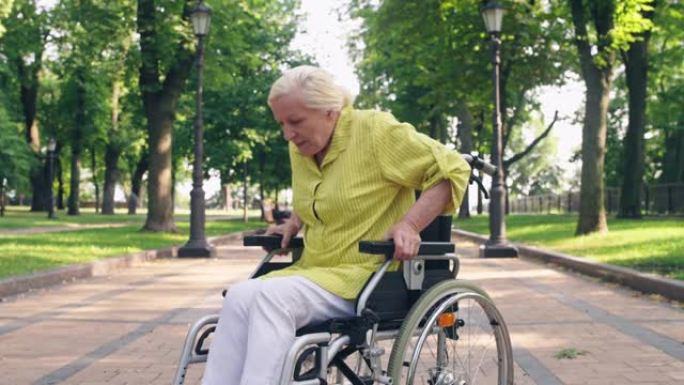 身患残疾的老年妇女试图从轮椅上站起来，感到疼痛