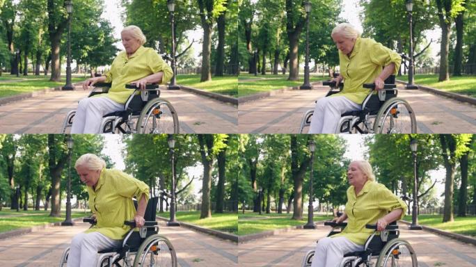 身患残疾的老年妇女试图从轮椅上站起来，感到疼痛