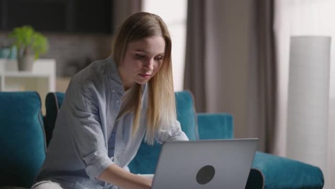严肃的年轻女性自由职业者在家自由职业者在笔记本电脑上打字电子邮件，专注的女孩在家用电脑在线学习坐在沙