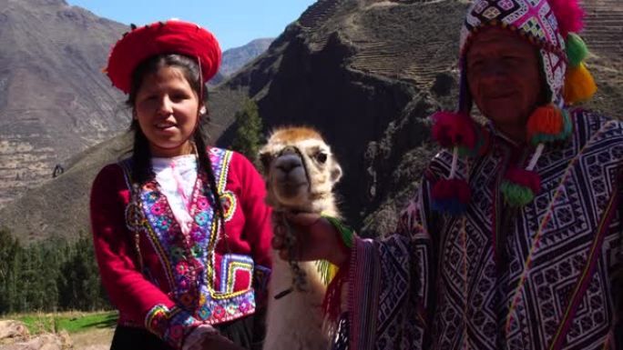 秘鲁父亲和女儿与美洲驼在秘鲁库斯科的圣谷