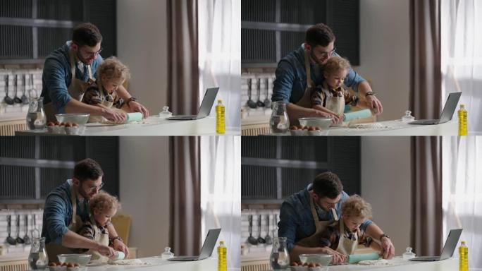 年轻的父亲正在学习他的小儿子做饭，在现代公寓的厨房桌子上滚动面团，在室内中等射击