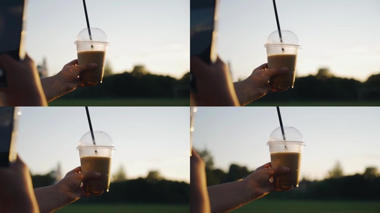 女孩手里拿着一杯咖啡，给它拍照。她在日落时拍照