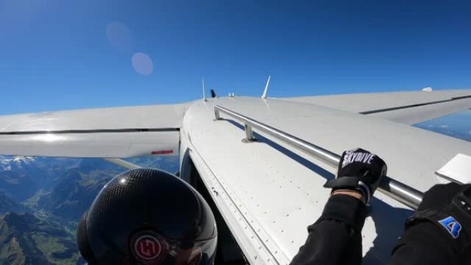 跳伞运动员从瑞士山区景观上方的飞机上降落