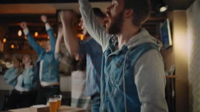 一群男女在酒吧里为世界杯国家队欢呼。球迷们通过在酒吧看电视来庆祝进球。篮球、曲棍球、棒球